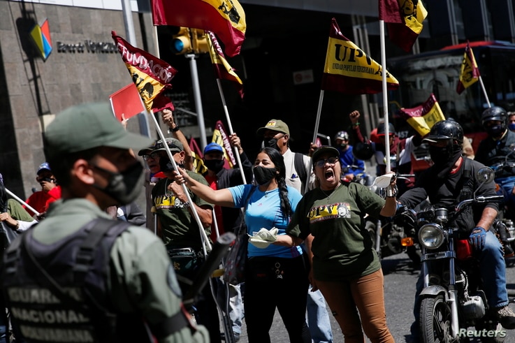 Members of Venezuelan People's Union (UPV) protest outside Venezuela's National Assembly building during the swear-in ceremony…