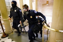 U.S. Capitol police officers take positions as protestors enter the Capitol building during a joint session of Congress.