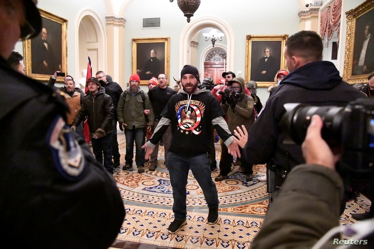 A supporter of President Donald Trump confronts police as Trump supporters demonstrate on the second floor of the U.S. Capitol in Washington, January 6, 2021