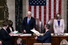 U.S. Vice President Mike Pence hands the West Virginia certification to staff as Speaker of the House Nancy Pelosi looks on.