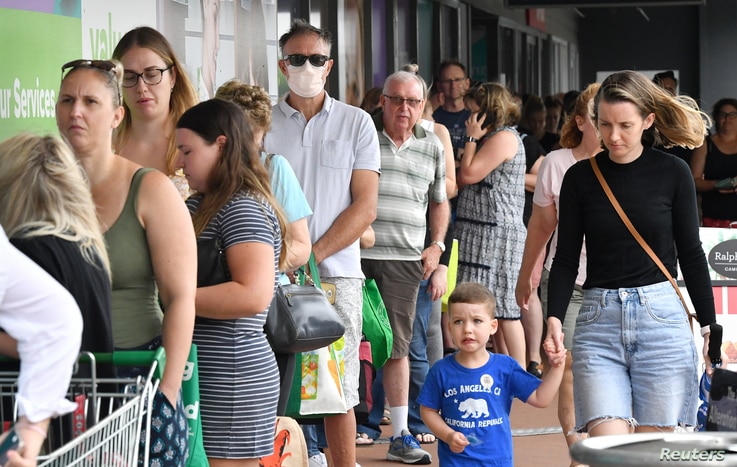 People line up to enter a grocery store before an impending lockdown due to an outbreak of the coronavirus disease (COVID-19)…