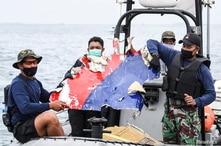 Indonesian Navy personnel carry debris believed to be from the Sriwijaya Air SJ-182 plane, which crashed into the sea, off the…