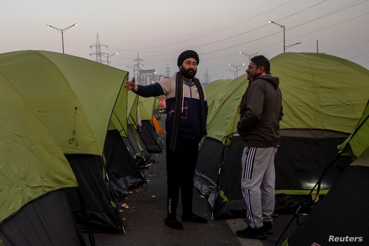 Farmers stand outside their tents at the site of a protest against new farm laws, at the Delhi-Uttar Pradesh border in Ghaziabad, India, Jan. 11, 2021.