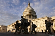 National Guard members walk in front of the U.S. Capitol after the House voted to impeach U.S. President Donald Trump.
