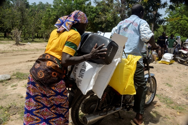 FILE - A Cameroonian displaced woman is seen loading her donated food onto a motorcycle outside a distribution center in Koza, in the extreme northern province, west of the Nigerian border, Sept. 14, 2016