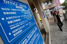 FILE - In this Dec. 30, 2011, photo,  a man walks past the US visa services entrance of the American Institute in Taiwan, the de facto American embassy, in Taipei, Taiwan.