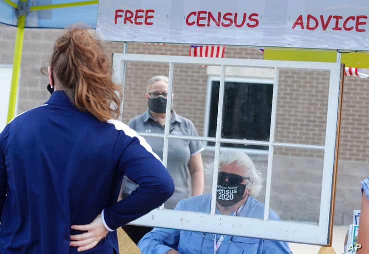 Amid concerns of the spread of COVID-19, census worker Ken Leonard wears a mask as he mans a U.S. Census walk-up counting site…