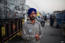 Farmer Harinder Singh, 28, stands for a photograph next to his tractor parked on a highway during a protest.