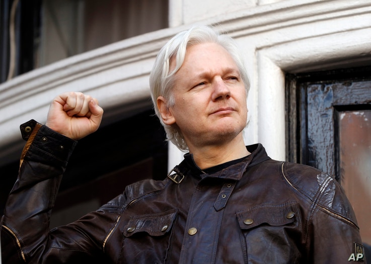 FILE - In this May 19, 2017 photo, WikiLeaks founder Julian Assange greets supporters outside the Ecuadorian embassy in London.