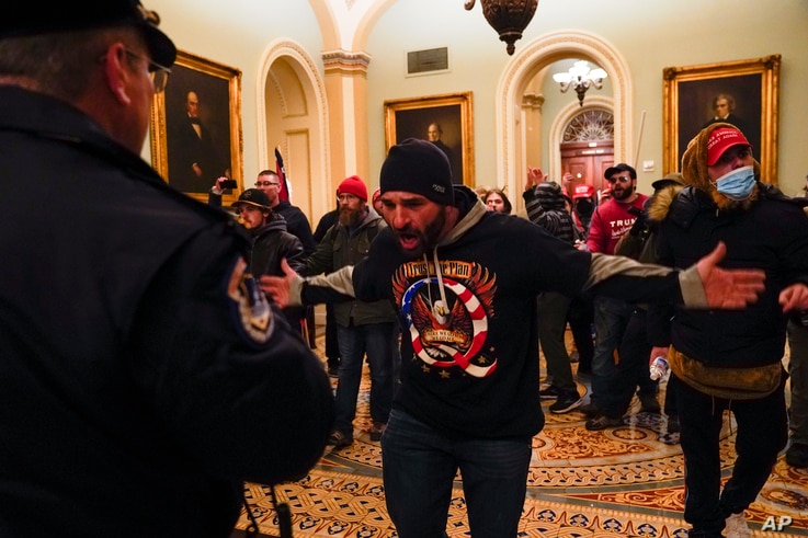 Protesters gesture to U.S. Capitol Police in the hallway outside of the Senate chamber at the Capitol.