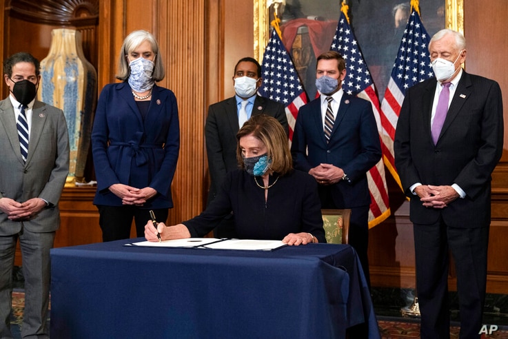 House Speaker Nancy Pelosi of Calif., signs the article of impeachment against President Donald Trump in an engrossment…