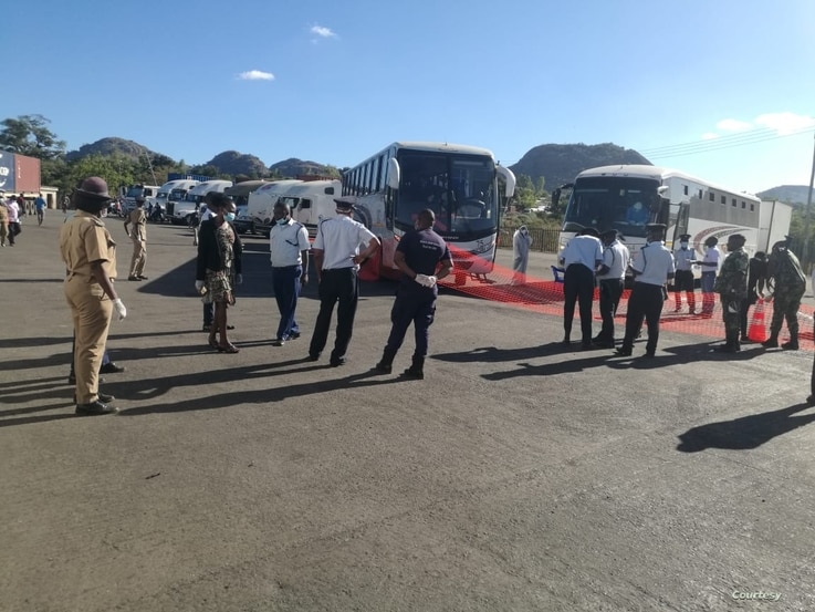 Immigration officers at Mwanza border wellcoming buses carrying Malawi returnees 
