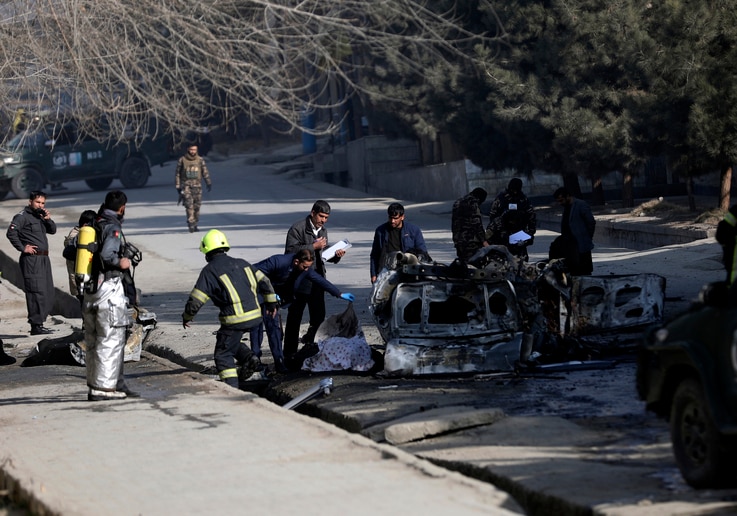 Afghan security officers inspect the site of a bombing attack in Kabul, Afghanistan, Sunday, Jan. 10, 2021. A roadside bomb…