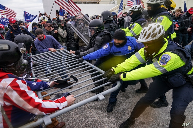 Supporters of President Donald Trump try to break through a police barrier at the Capitol in Washington, Jan. 6, 2021.