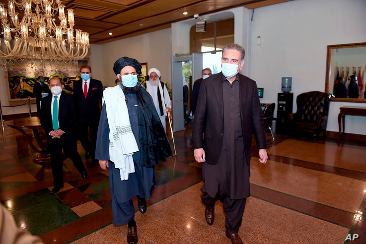 Pakistan's Foreign Minister Shah Mahmood Qureshi, right, and Mullah Abdul Ghani Baradar, head of a Taliban political team, arrive at the Foreign Ministry for talks, in Islamabad, Dec. 16, 2020. (Photo provided by Pakistan's Ministry of Foreign Affairs) 