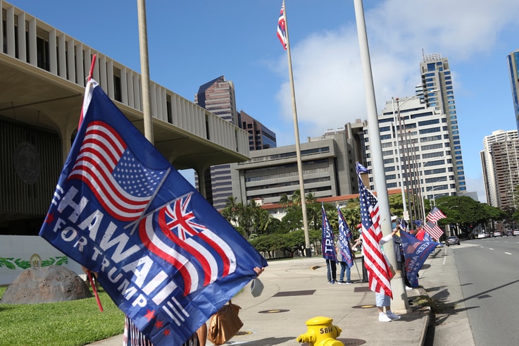 Demonstrators carry American and Trump campaign flags during a protest outside the Hawaii State Capitol in Honolulu on…